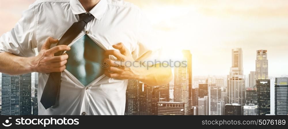 Business super hero hover over city skyline. Business superhero. Young businessman showing super hero suit under his shirt down town on sunset.