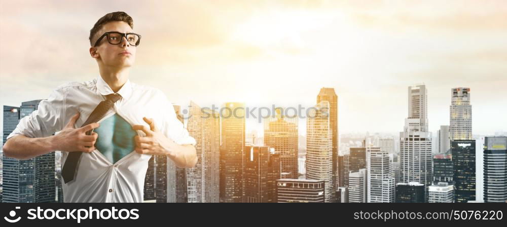 Business super hero hover over city skyline. Business superhero. Young businessman showing super hero suit under his shirt down town on sunset.