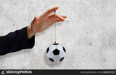 Business tactics. Close up of businessman hand and ball hanging on rope