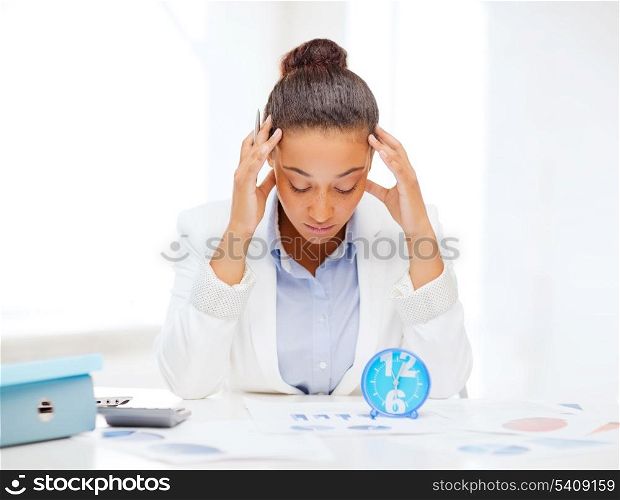 business, tax, deadline concept - african businesswoman working with calculator and clock in office