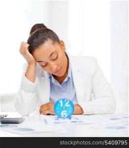 business, tax, deadline concept - african businesswoman working with calculator and clock in office