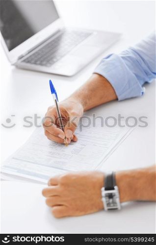 business, tax, office, school and education concept - man filling a form