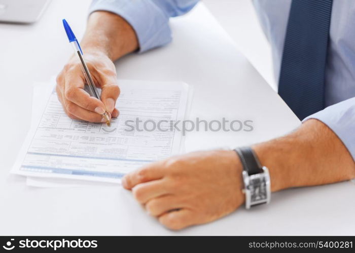 business, tax, office, school and education concept - man filling a form