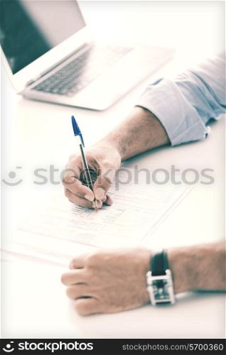 business, tax, office, school and education concept - man filling a form