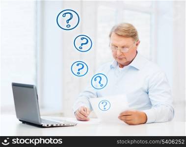 business, tax, office, school and education concept - old man in eyeglasses filling a form at home