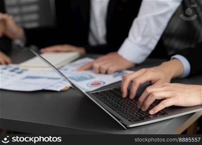 Business team analyze business analytic or business intelligence dashboard on laptop screen show graph and chart with statistic in harmony office. Analyst team meeting researching, planning strategy.. Closeup to view hand using laptop to analyze financial data in harmony office.