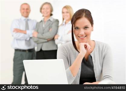 Business team attractive woman with happy colleagues posing in back
