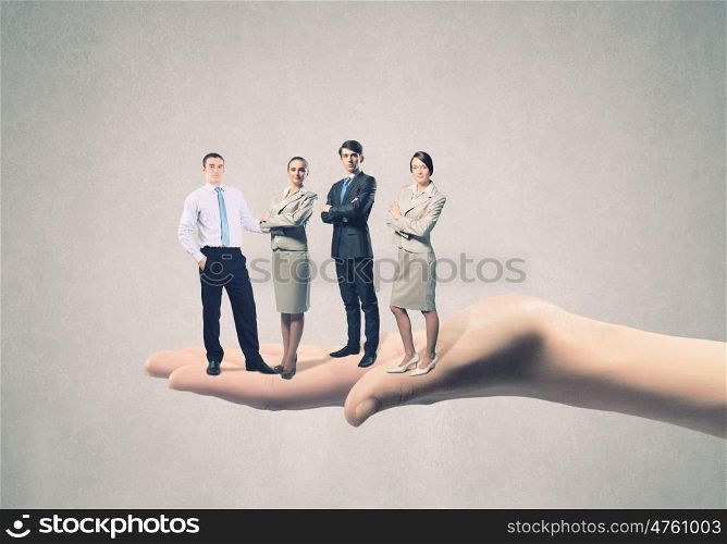 Business team. Business people of different professions standing on palm