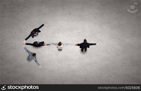 Business team. Business people with stretched arms making figure of arrow