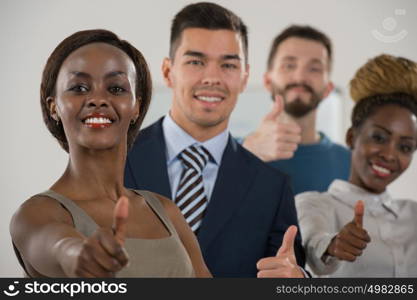 Business team celebrating a triumph with thumbs up