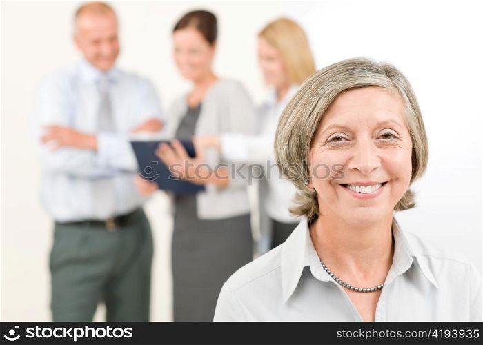 Business team close-up of senior businesswoman with attractive happy colleagues