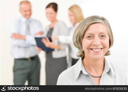 Business team close-up of senior businesswoman with attractive happy colleagues