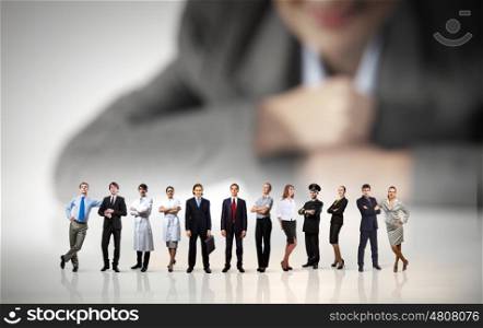 Business team concept. Businesswoman looking at group of businesspeople in miniature