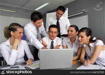 Business team gathered around laptop