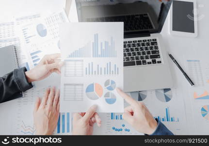 Business team hands at working with financial plan and a tablet, laptop on office desk, Top view shot.