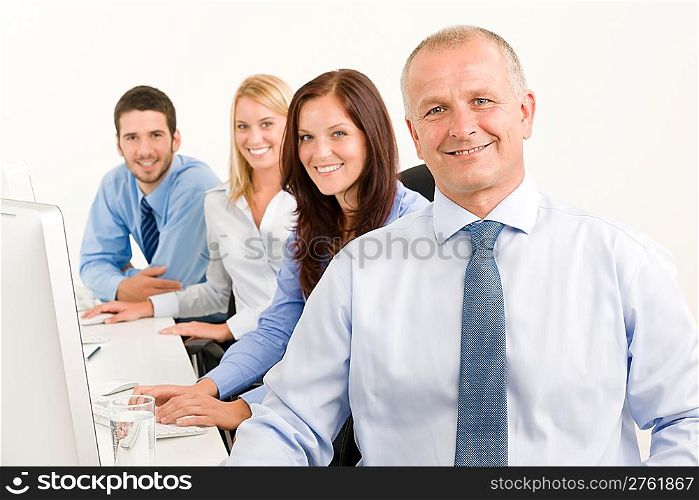 Business team handsome mature manager sitting behind computer table office