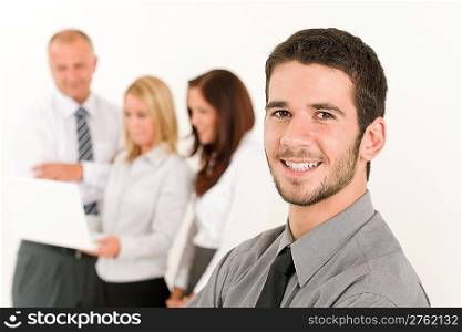 Business team handsome young man with colleagues posing in back