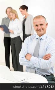 Business team happy mature businessman with attractive colleagues looking file