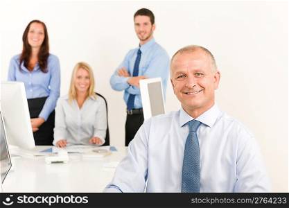Business team happy mature businessman with attractive colleagues looking files