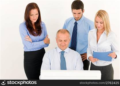 Business team mature businessman with attractive colleagues looking computer