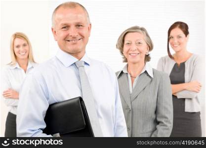 Business team mature businessman with attractive happy colleagues in office