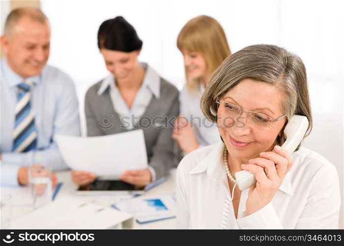 Business team meeting executive senior businesswoman calling on phone