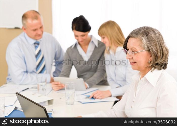 Business team meeting executive senior businesswoman with colleagues looking tablet