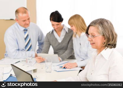 Business team meeting executive senior businesswoman with colleagues looking tablet