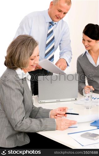 Business team meeting executive senior businesswoman with colleagues pointing report