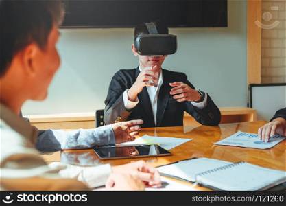 Business team meeting using Virtual Reality simulator headset and developing a new project