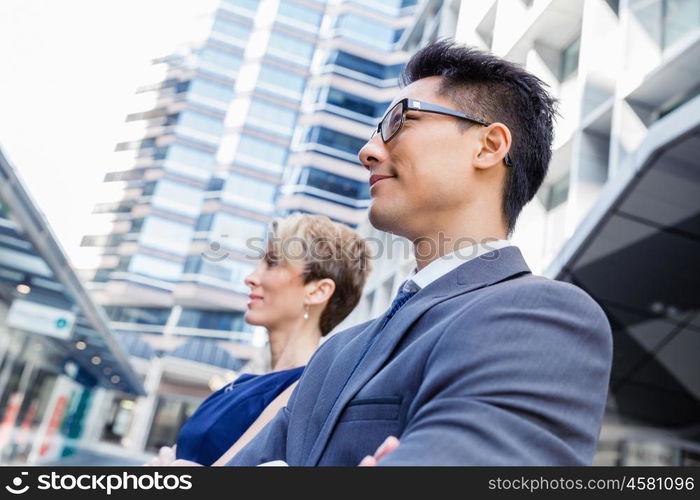 Business team members standing next to each other in business district. Serious about success and determined