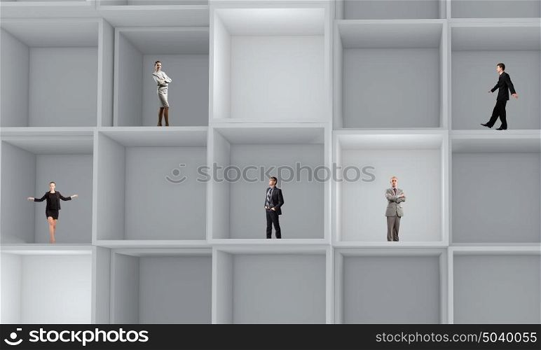 Business team. Miniatures of business people standing in cube