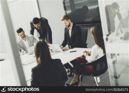 Business team on meeting in modern bright office interior and working on laptop
