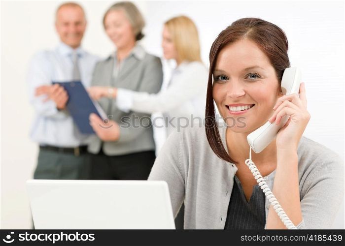 Business team pretty businesswoman calling phone happy colleagues looking folder
