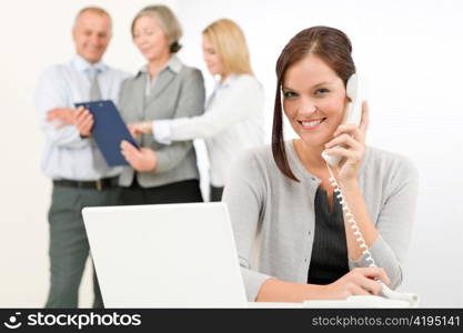 Business team pretty businesswoman calling phone happy colleagues looking folder