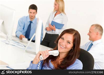 Business team pretty businesswoman holding phone happy colleagues around table