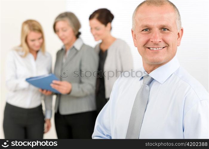 Business team senior businessman in front with attractive happy colleagues