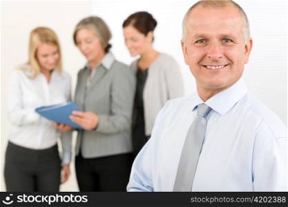 Business team senior businessman in front with attractive happy colleagues