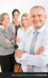 Business team senior businessman with attractive happy colleagues in office