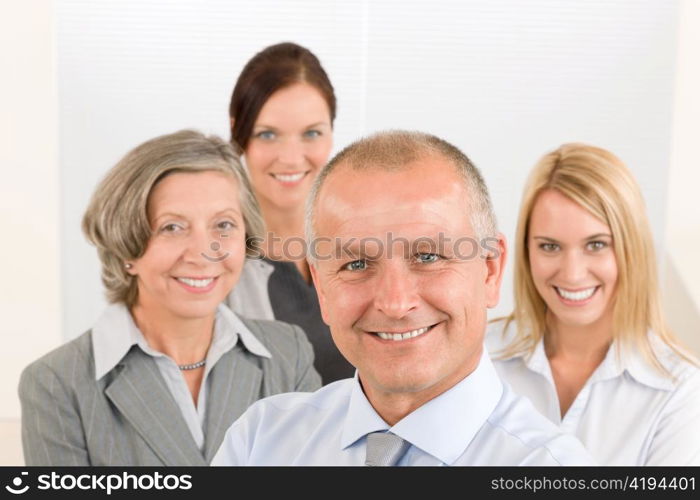 Business team senior businessman with attractive happy colleagues in office