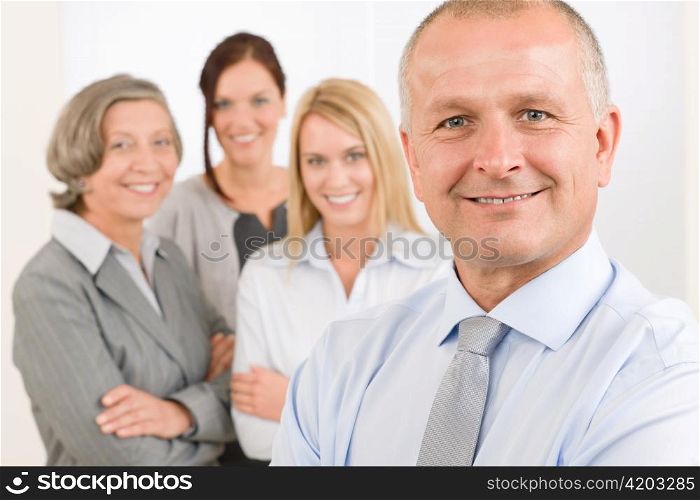 Business team senior businessman with attractive happy colleagues in office