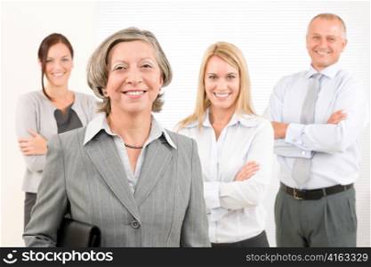 Business team senior businesswoman with attractive happy colleagues in office