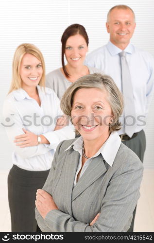 Business team senior businesswoman with attractive happy colleagues in office