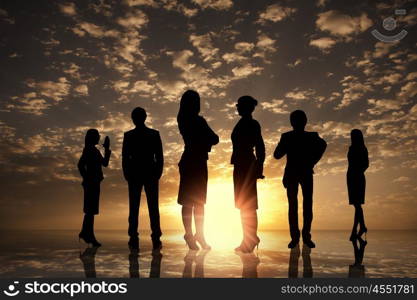 Business team. Silhouettes of business people against sunset landscape