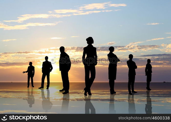 Business team. Silhouettes of business people against sunset landscape