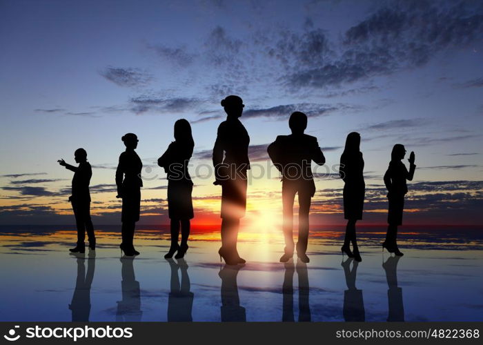 Business team. Silhouettes of business people against sunset landscape