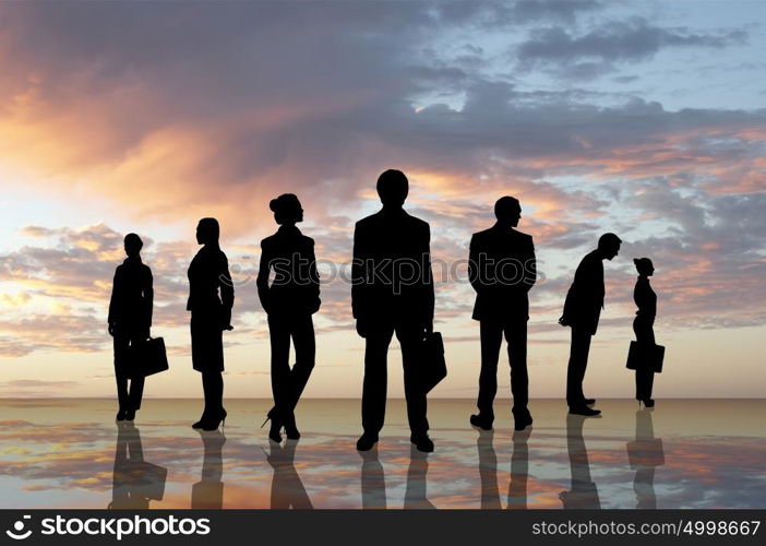 Business team. Silhouettes of business people against sunset landscape