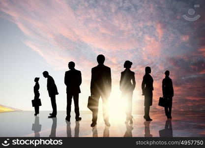 Business team. Silhouettes of business people standing in line