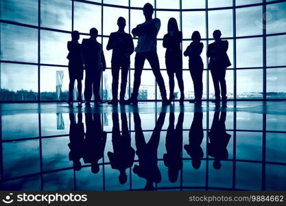 Business team standing against window with leader in front