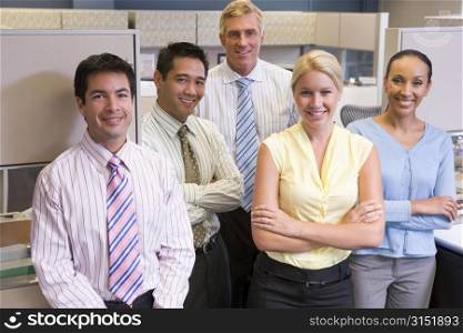 Business team standing in cubicle smiling